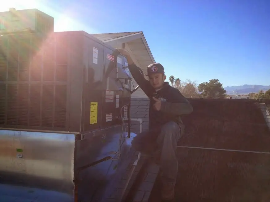 HVAC technician performing AC Tune-Up on a rooftop unit in Waimanalo